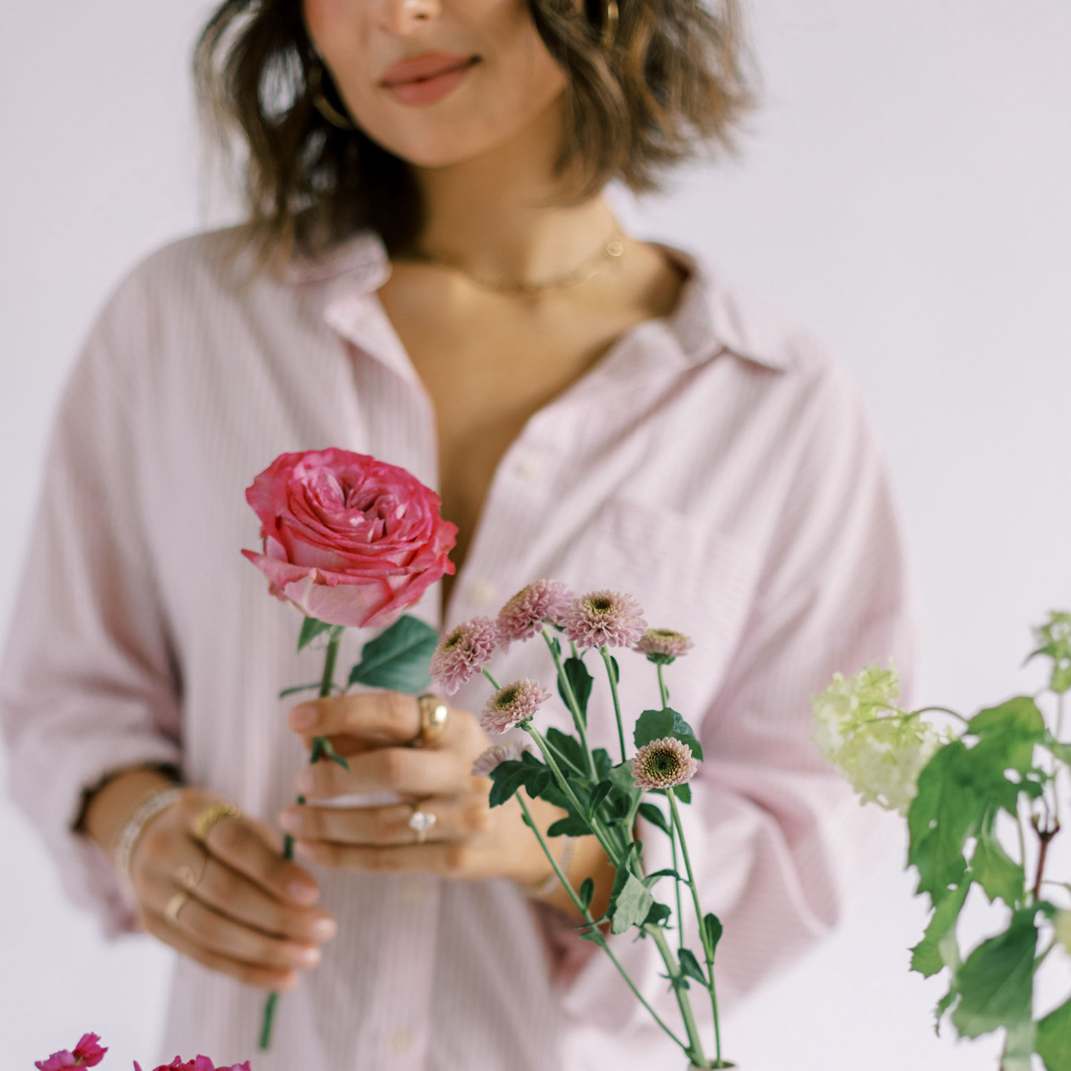 Woman in a white shirt holding a mug by the window, symbolising calm and improved wellbeing through hormone health support